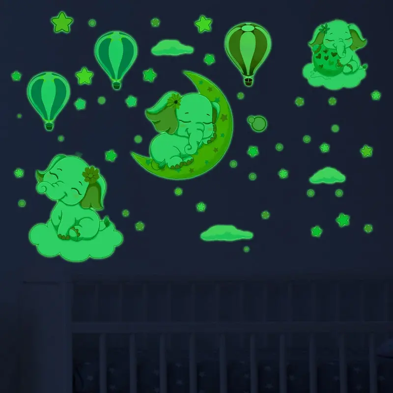 Sød selvlysende wallsticker med tre små elefant unger blandt luftballoner og stjerner. Sød selvlysende wallsticker med tre små elefant unger mm.